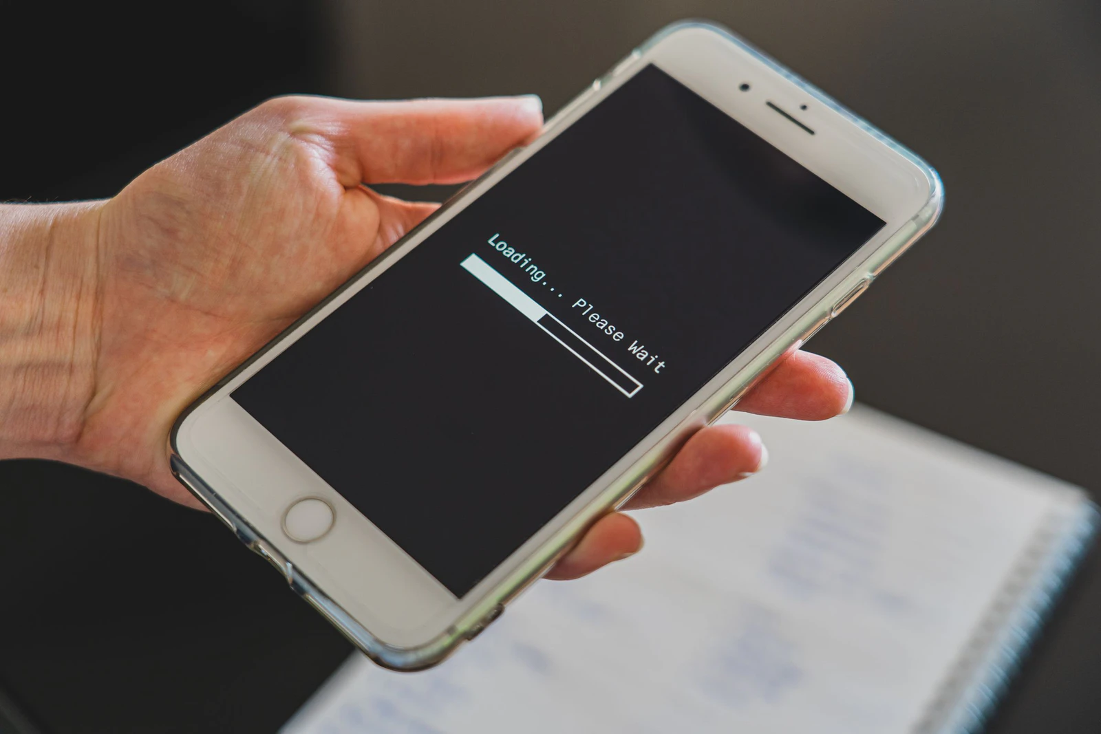 Pessoa segurando o celular enquanto a conexão com a internet carrega na tela