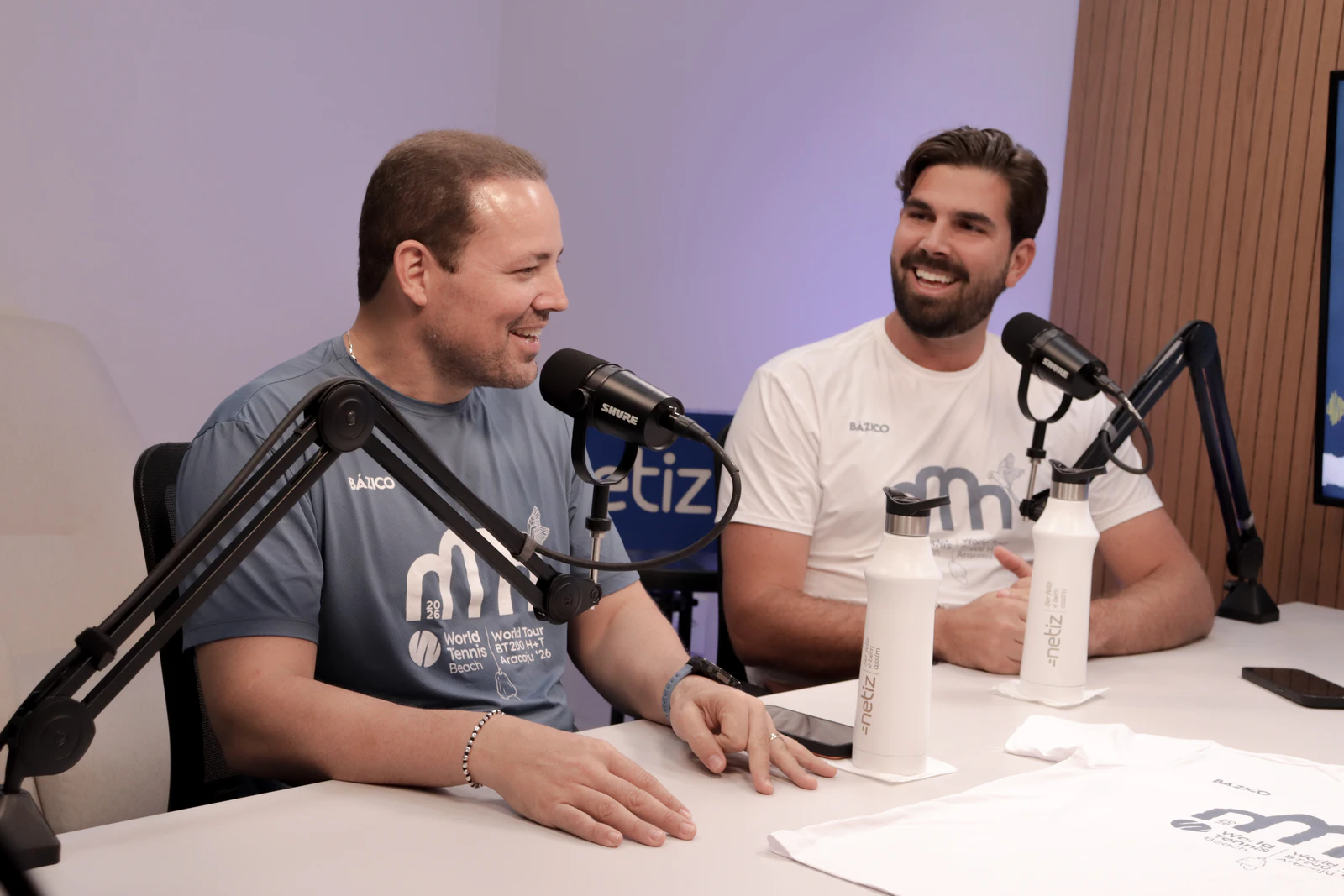 Os dois organizadores do BT200 Aracaju sorriem durante a conversa no estúdio do PodConectar