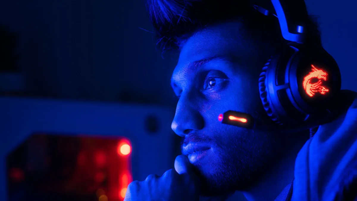 Jogador com headset concentrado numa partida no PC, situação em que o ping alto nos jogos faz a ação demorar a registrar