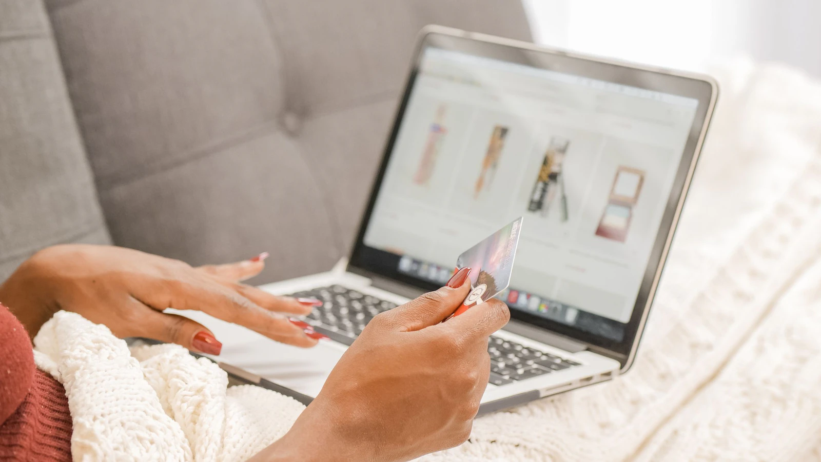 Pessoa fazendo compras on-line no notebook com o cartão na mão, situação em que os cookies guardam o carrinho de compras