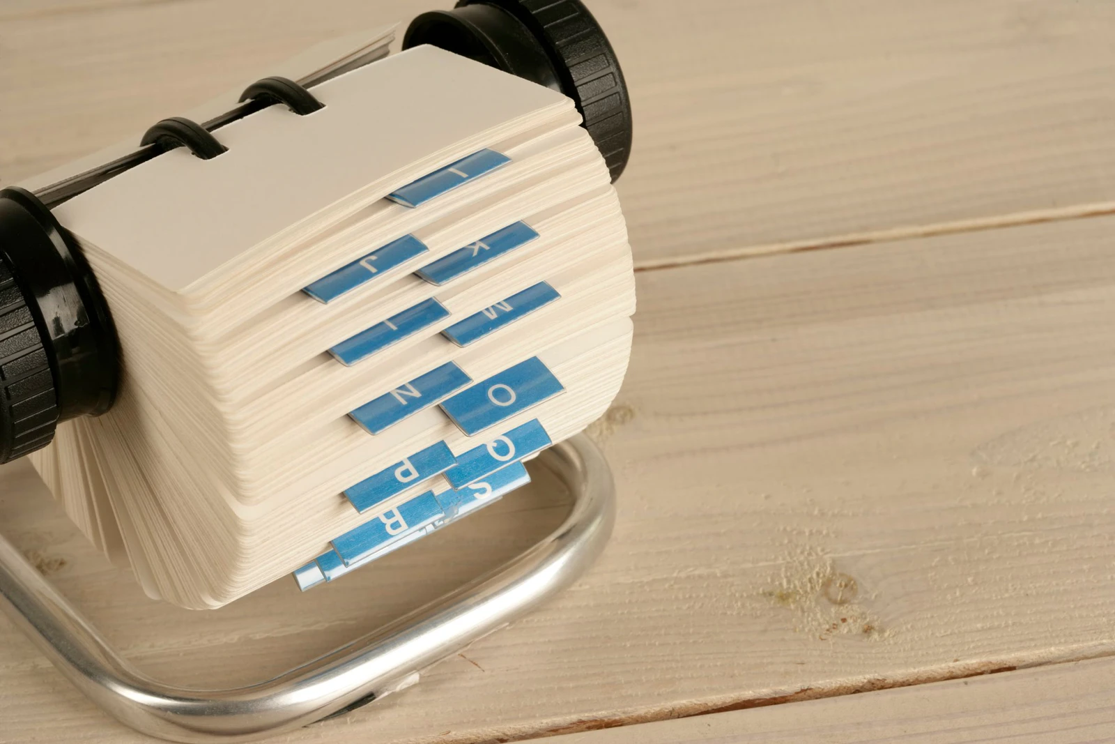 Fichário rotativo com cartões e abas do alfabeto, uma espécie de agenda de contatos em papel, ilustrando como o DNS guarda endereços